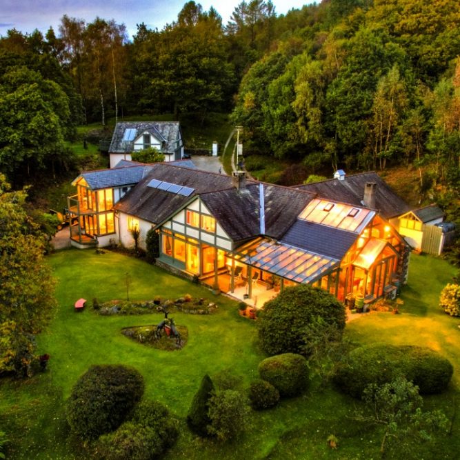 A twilight house surrounded with a plants and trees